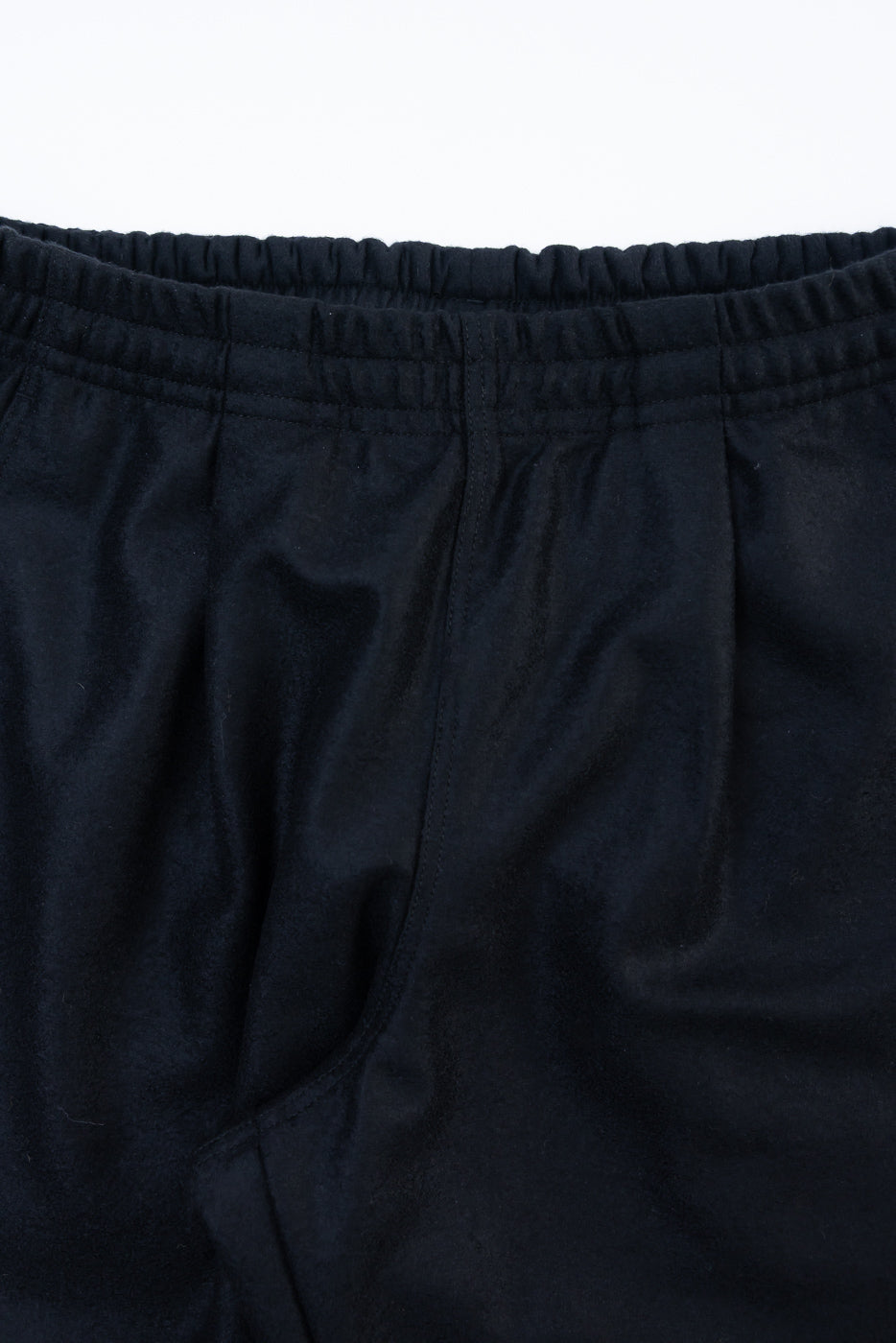 Close-up of front waistband and fabric texture on black wool moleskin trousers