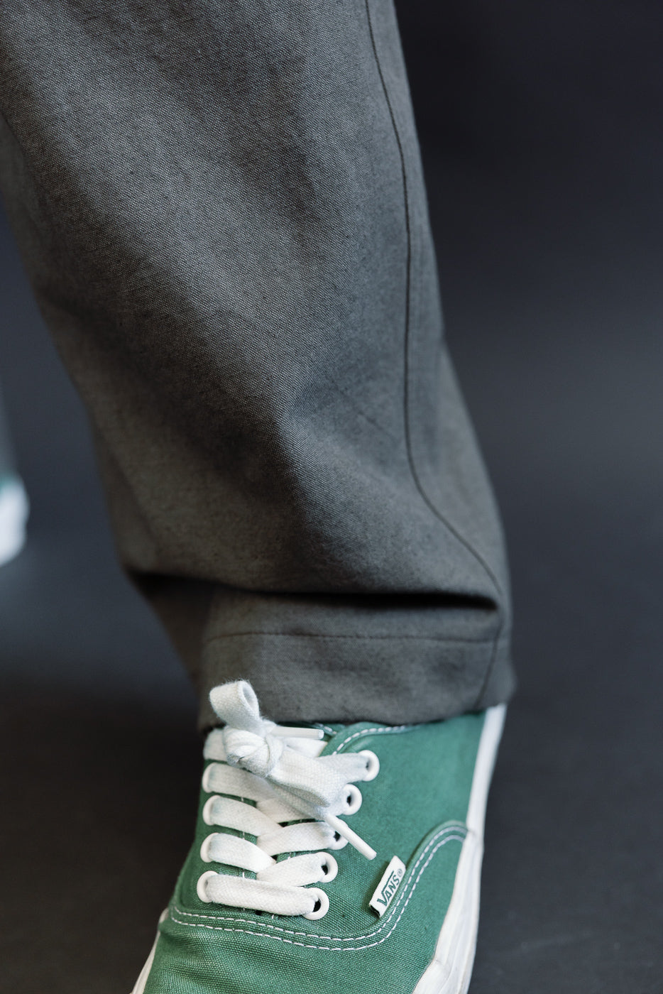 Close-up of lower front leg of men's dark moss gray canvas trousers on athletic male model, 5'9