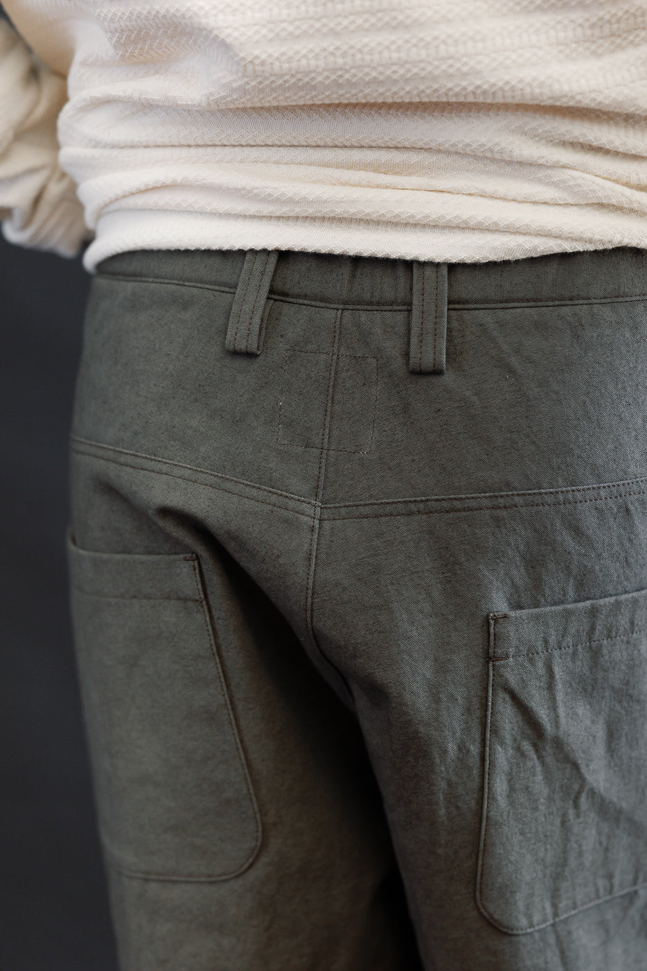 Close-up of back of dark moss gray canvas trouser, male model 5'9