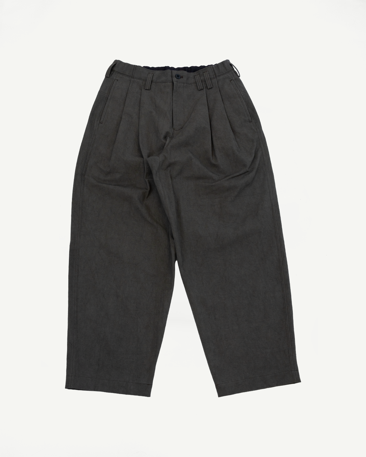Flat lay front view of dark moss gray canvas trousers, pleated, showing waistband and pockets.