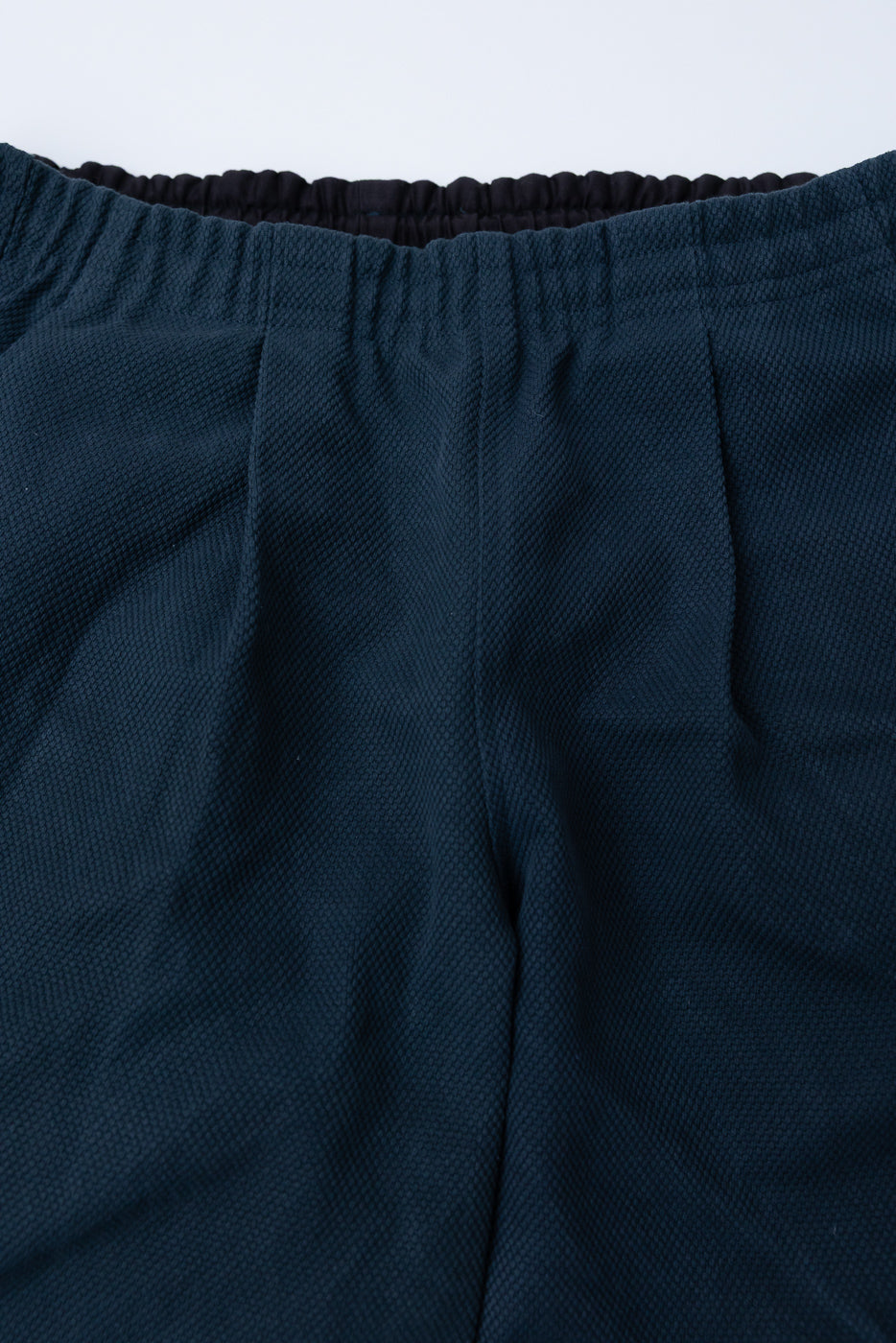 Close-up of JM4623 - Sashiko Ump Pants in Iron Navy, highlighting the textured knit fabric, elasticized waistband, and detailed stitching typical of premium Japanese workwear from Dant.