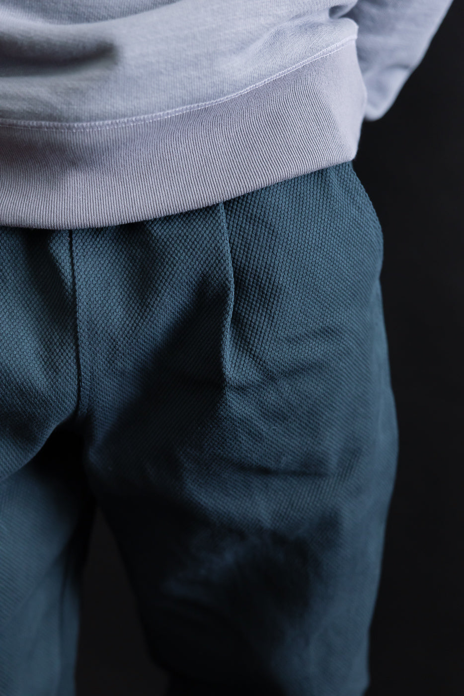 Close-up of JM4623 - Sashiko Ump Pants - 280 Iron Navy, showcasing the textured sashiko fabric with detailed stitching, pleated front, and large pocket, emphasizing the garment's structure and unique drape.