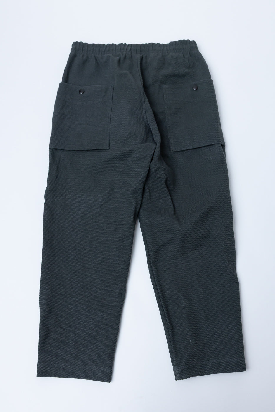 JM4623 - Sashiko Ump Pants feature a dark, textured weave with straight legs and elastic waistband, highlighted by large side patch pockets, showcasing Dant's dedication to heritage-inspired, premium menswear craftsmanship.