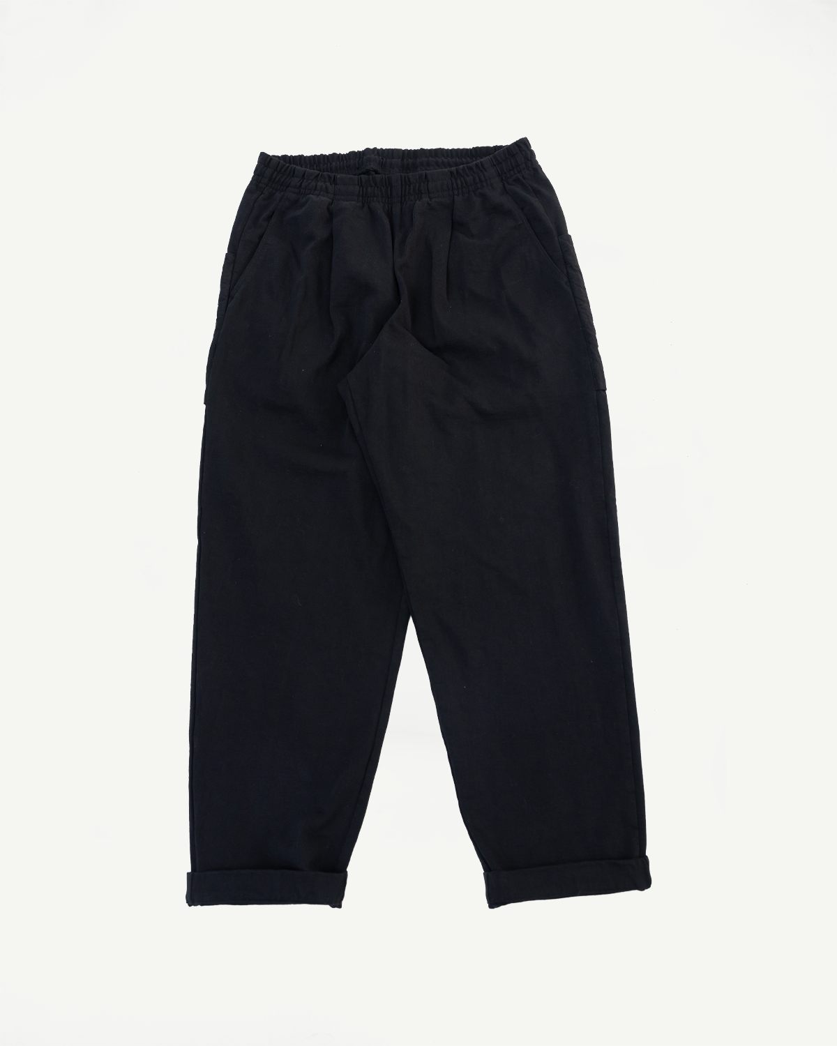 Front view flat lay of black casual drawstring trousers with cuffed hems.