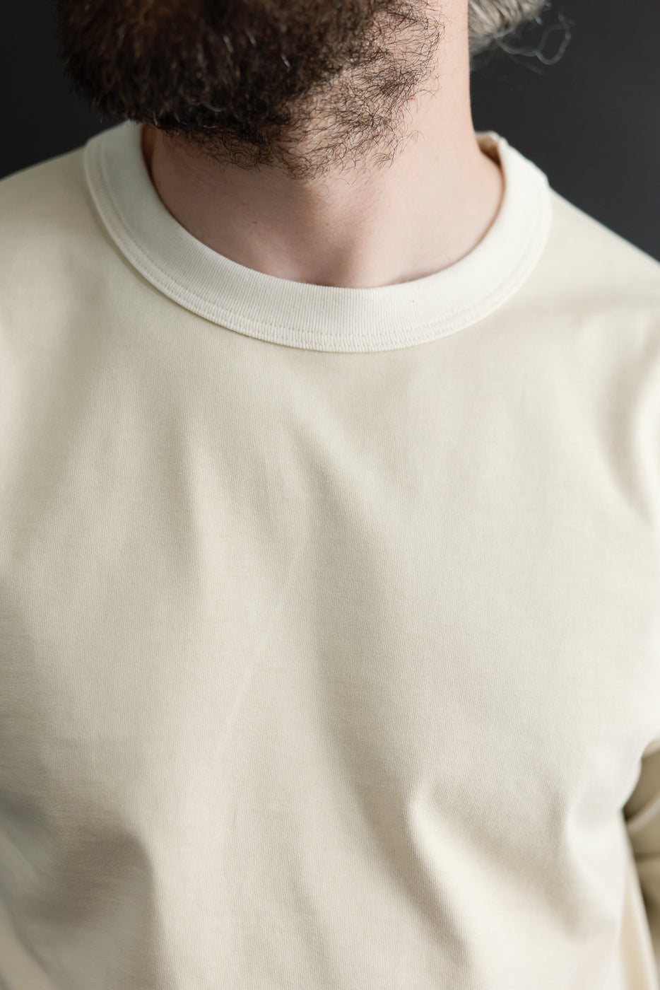 Close-up front view of cream long-sleeve tee on male model, 5'9