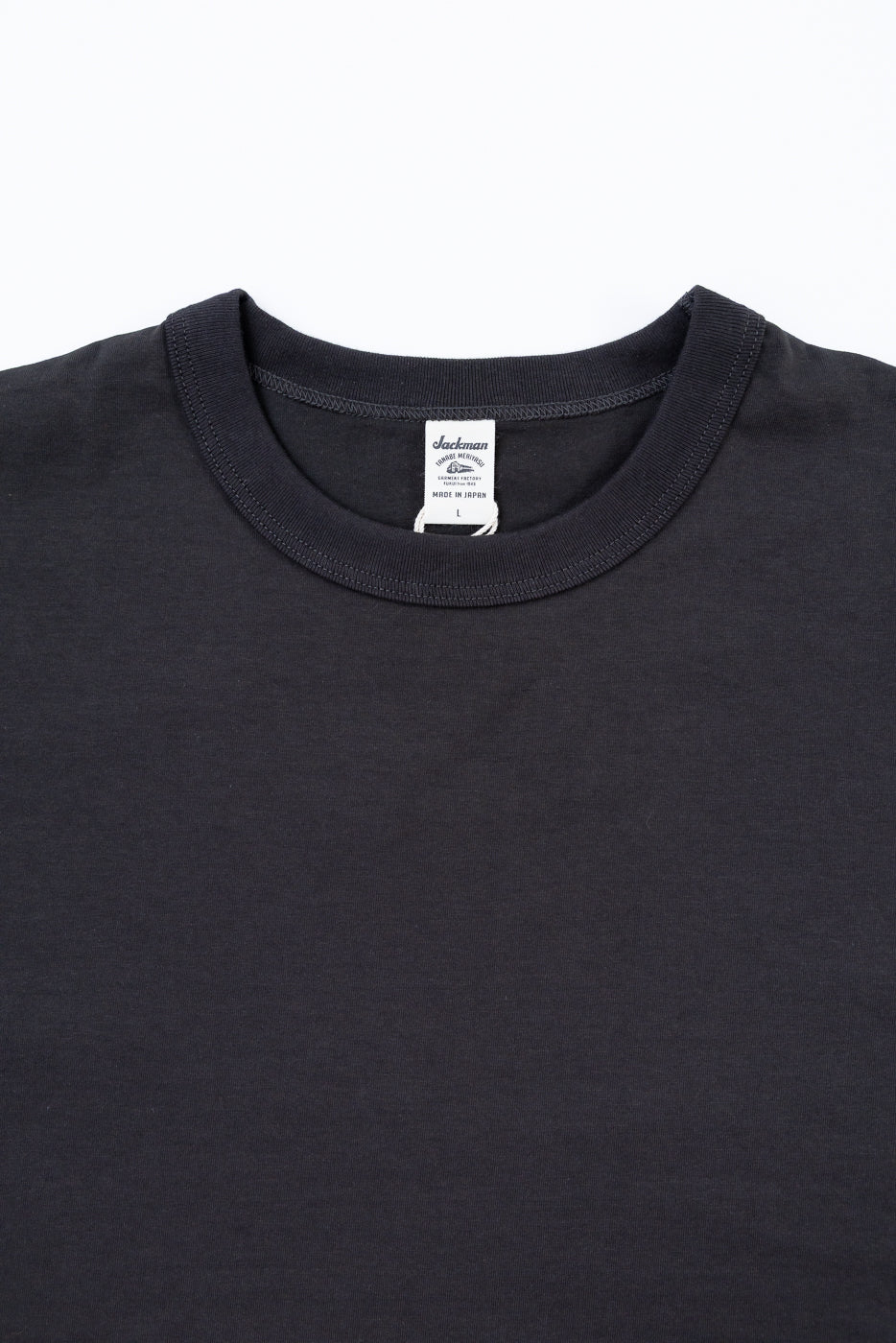Black t-shirt with a brand label on a white background