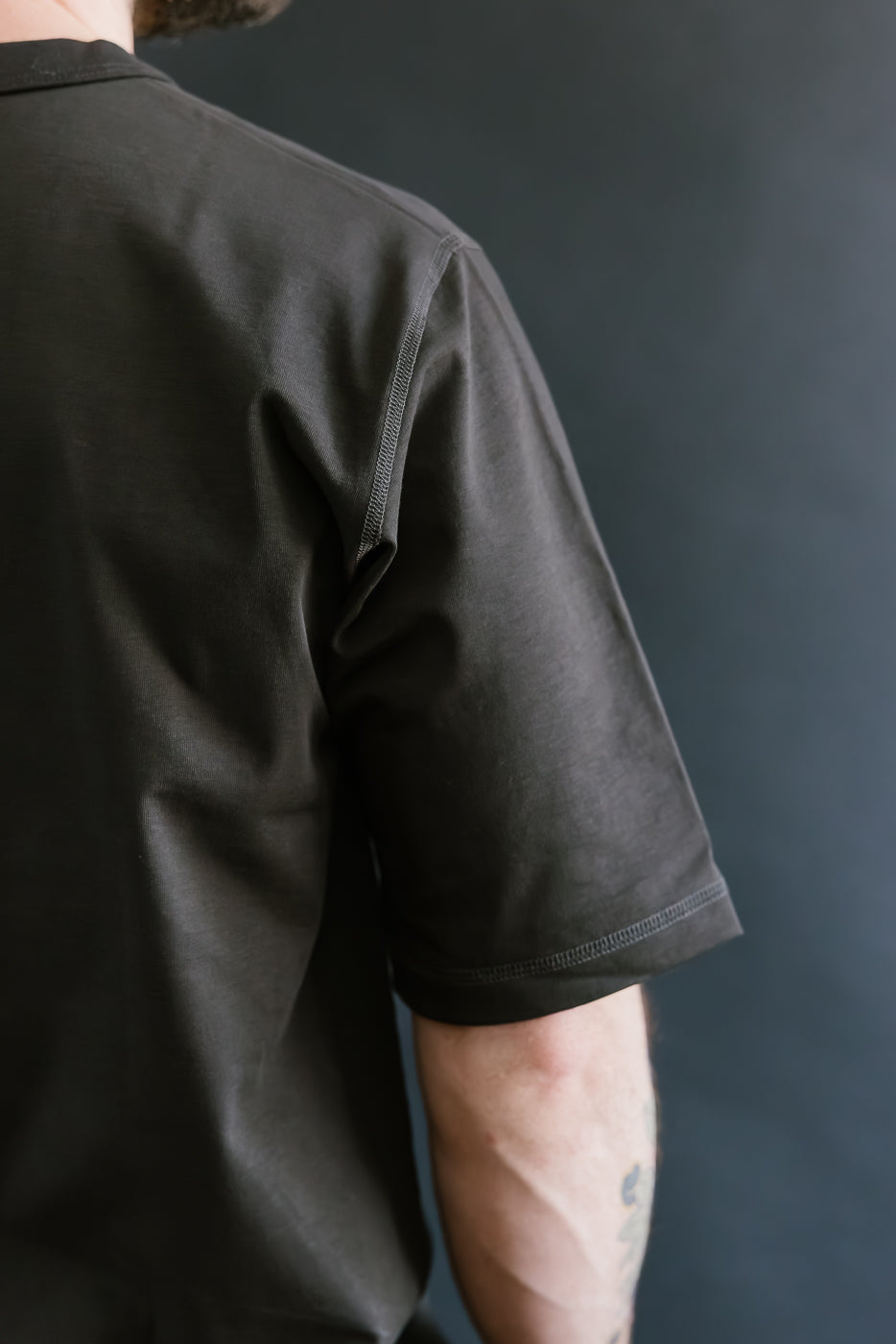 Person wearing a black shirt against a dark background
