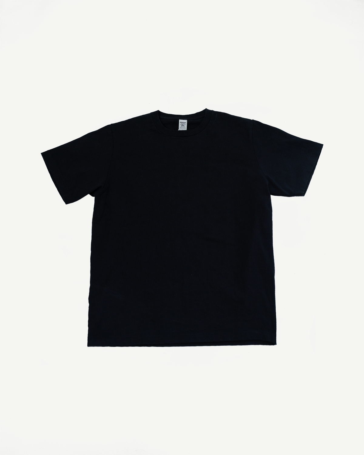 Black crew neck t-shirt flat lay, front view, showing tag detail and ribbed collar