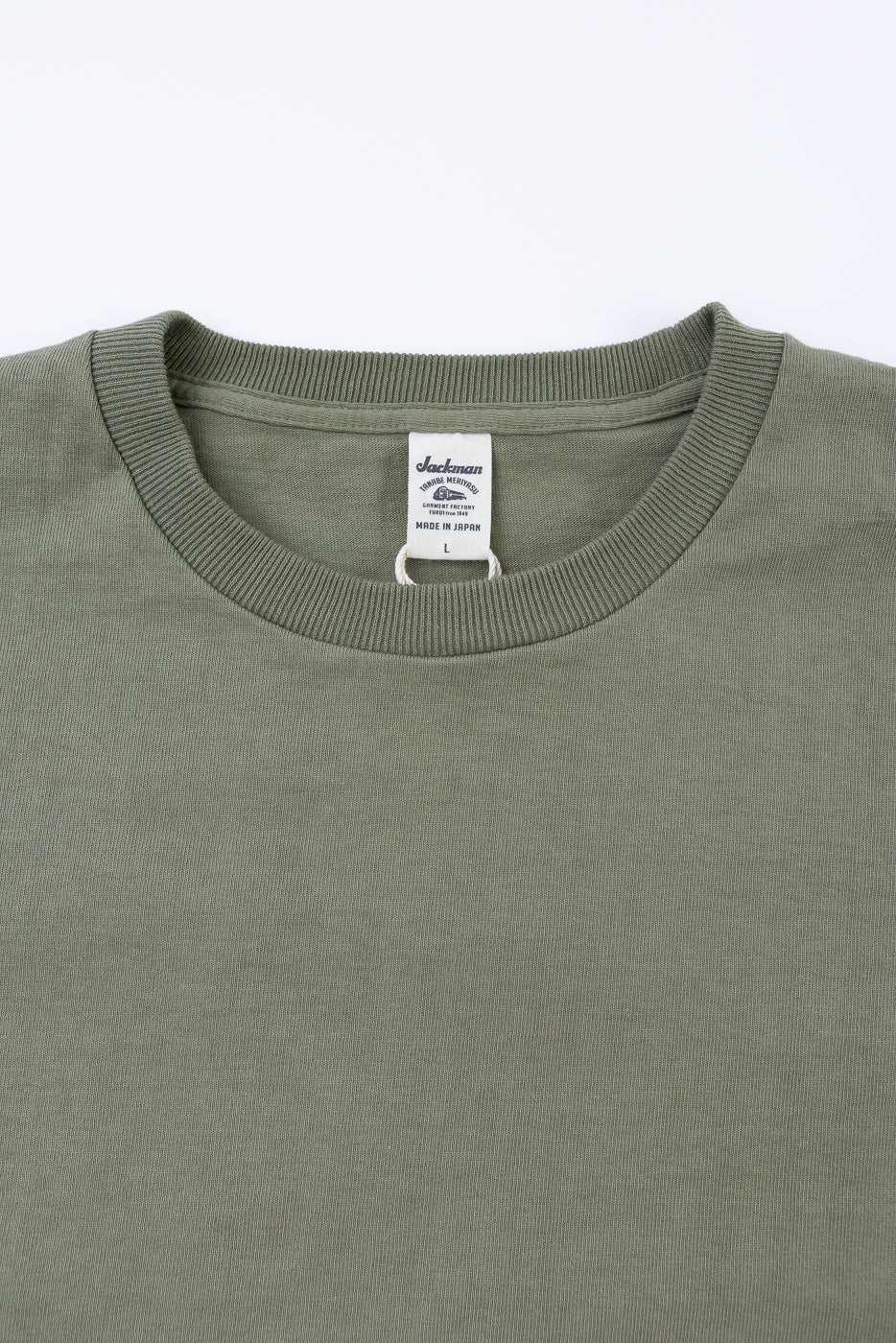 Close-up of a green sweatshirt with a brand label on a white background