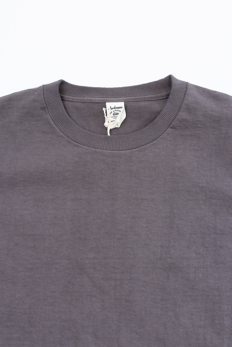 Close-up front view of gray crewneck tee, showing ribbed collar and brand tag detail