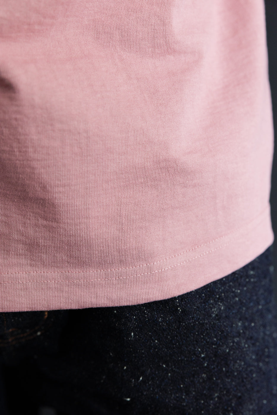 Close-up front hem of pink tee on male model, 5'9