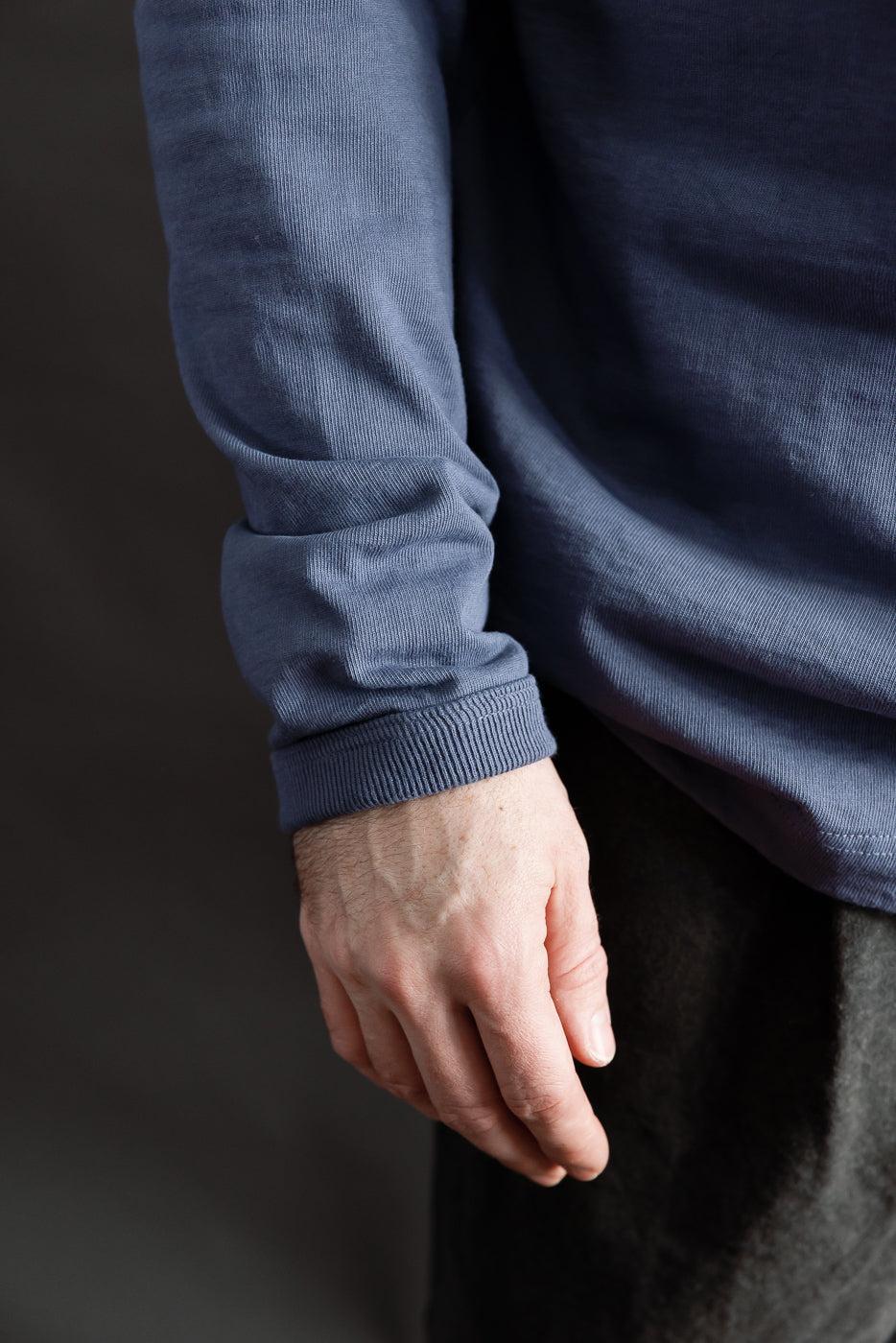 Close-up of classic navy Jackman Dotsume LS T-shirt sleeve cuff on male model, left side.