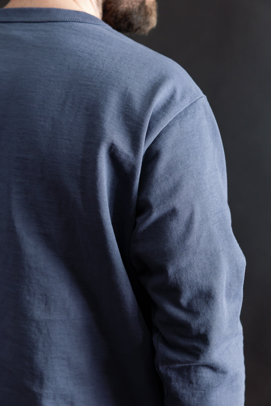 Close-up of classic navy Jackman dotsume long sleeve T-shirt back on male model, showing fabric texture, athletic build, from Dant contemporary casual apparel.