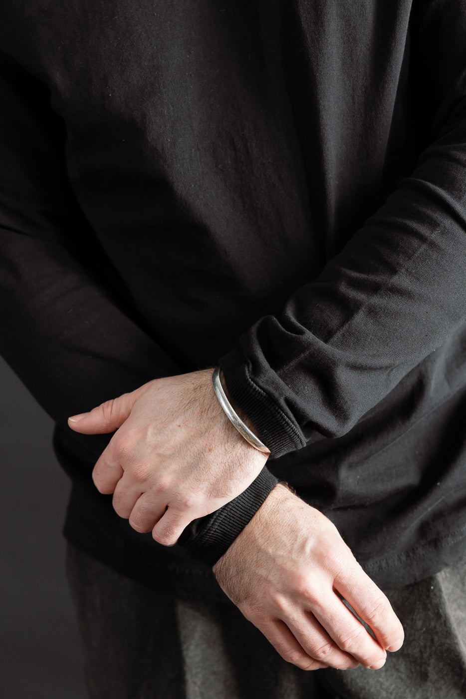 Close-up of black long sleeve t-shirt cuff, front side, on 5'9