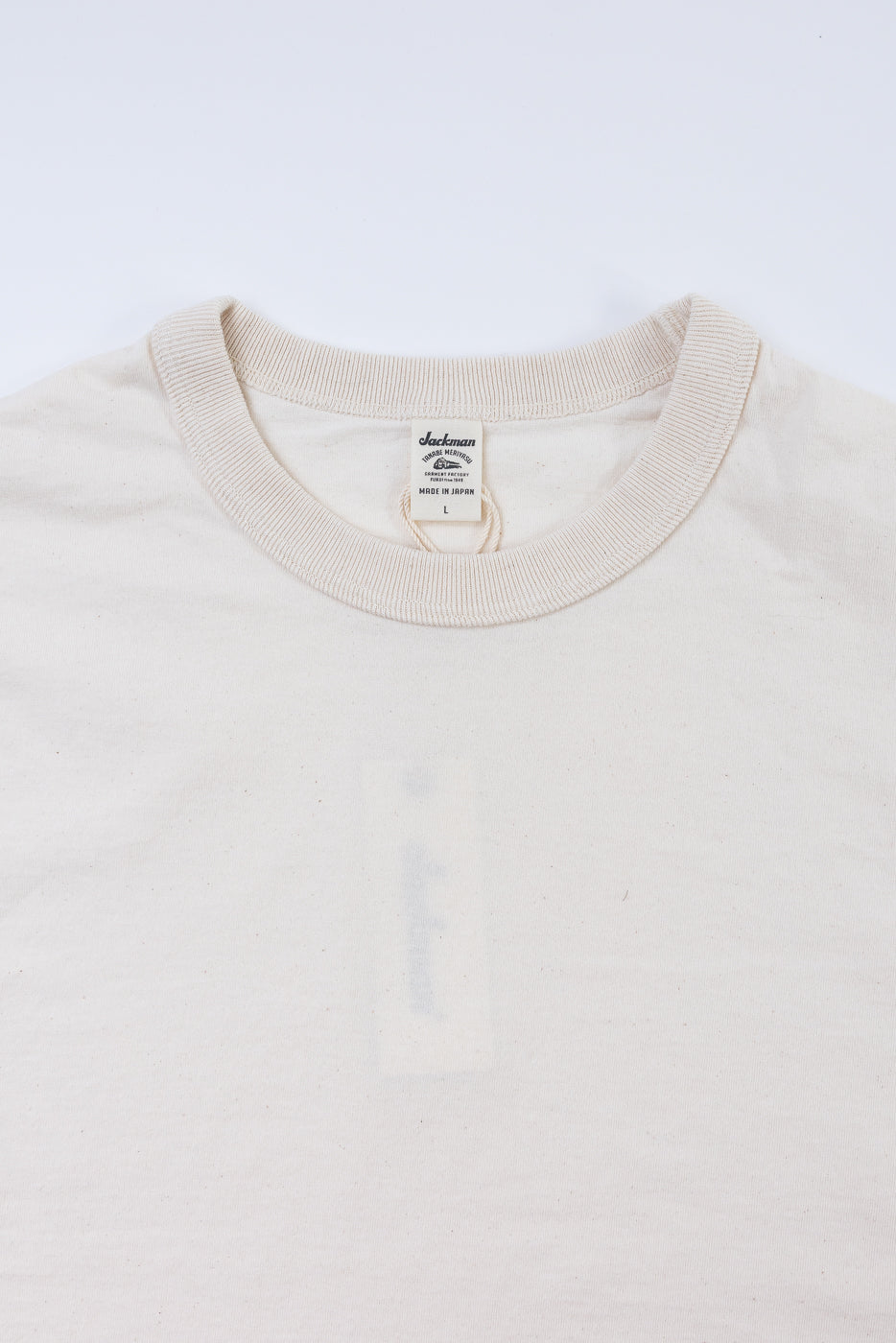 Beige sweater with a brand label on a white background