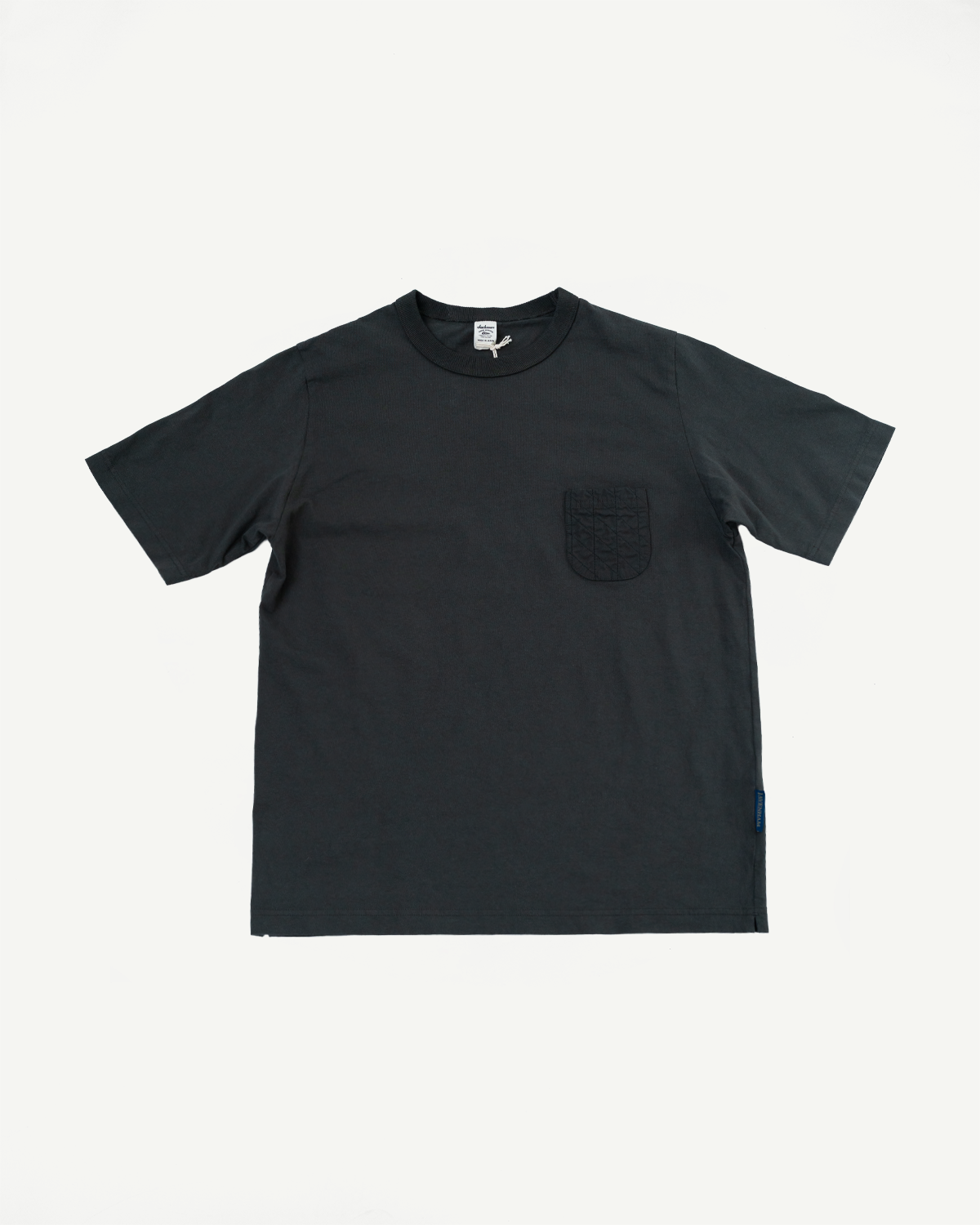 Black short sleeve t-shirt flat lay front view, quilted chest pocket, ribbed crew neck, side tag detail