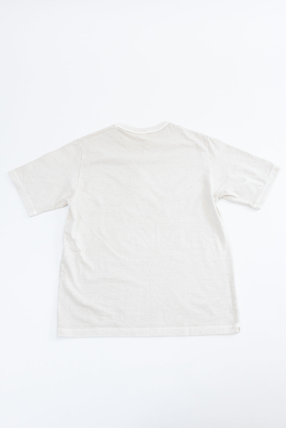 Flat lay back view of off-white short-sleeve t-shirt, showing crew neck, relaxed fit, and clean hem detail.