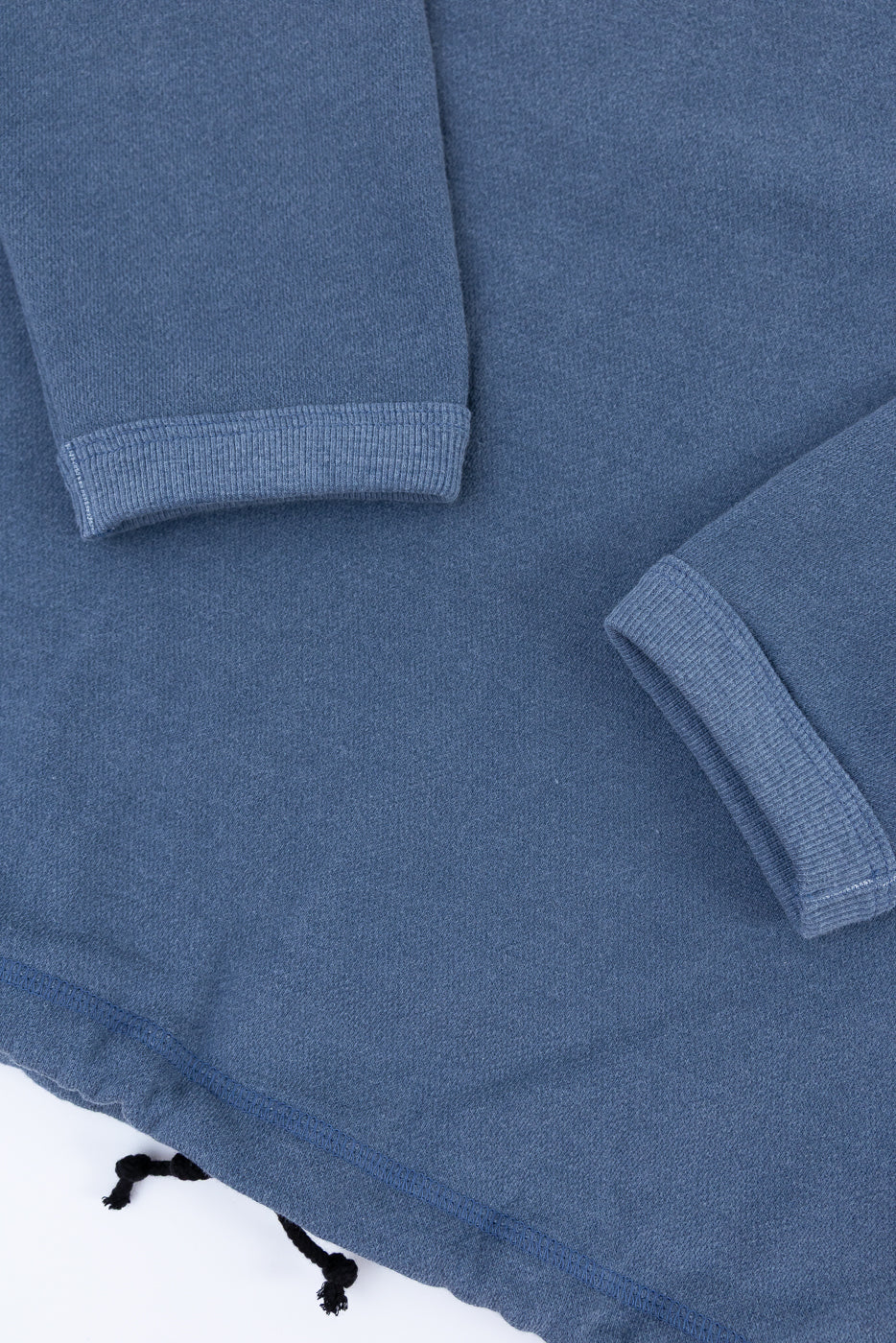 Close-up of a blue fleece blanket with folded edges on a white background
