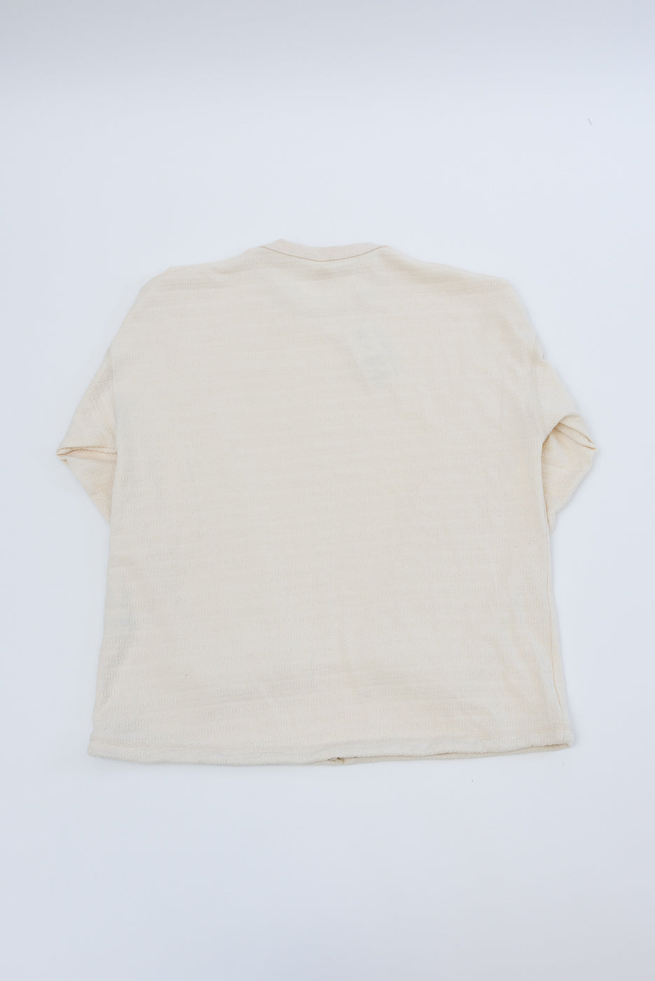 Flat lay of ecru long sleeve t-shirt, back view, showing collar and hem details.