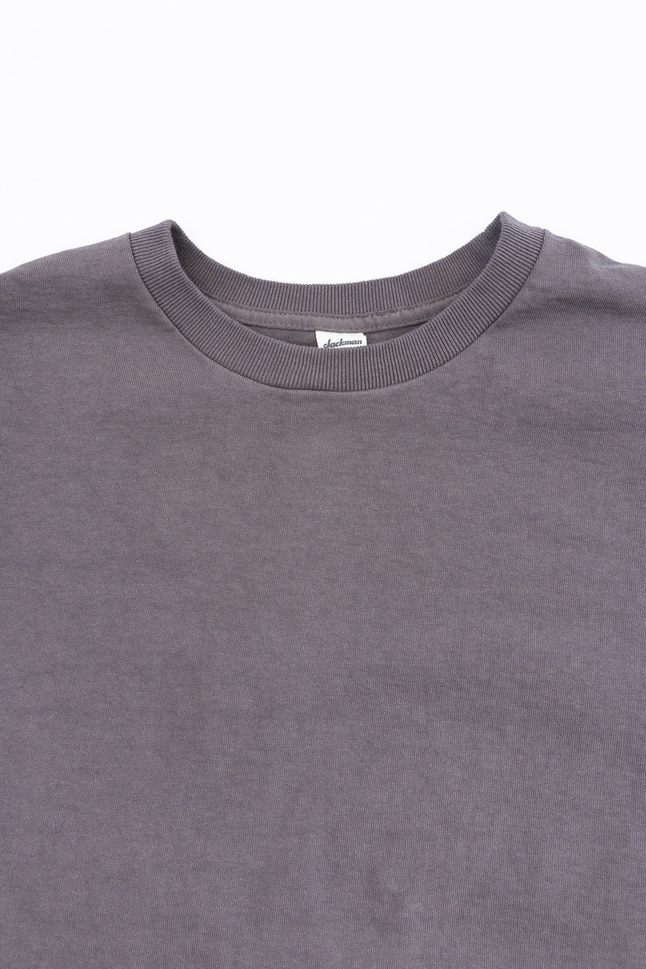 Close-up front view of gray crewneck t-shirt with ribbed collar and tag detail