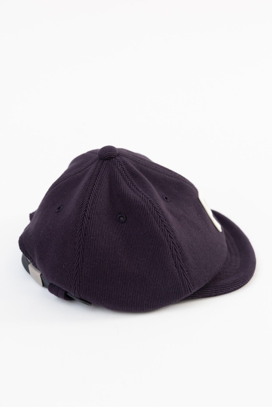 Back side view of a navy corduroy baseball cap showing ribbed texture and adjustable strap.