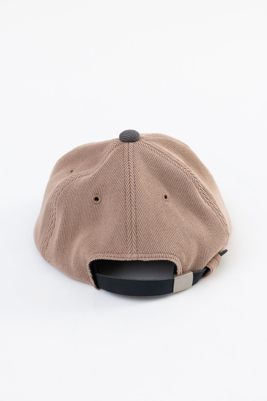 Back view of a tan corduroy baseball cap showing the adjustable strap and fabric texture.