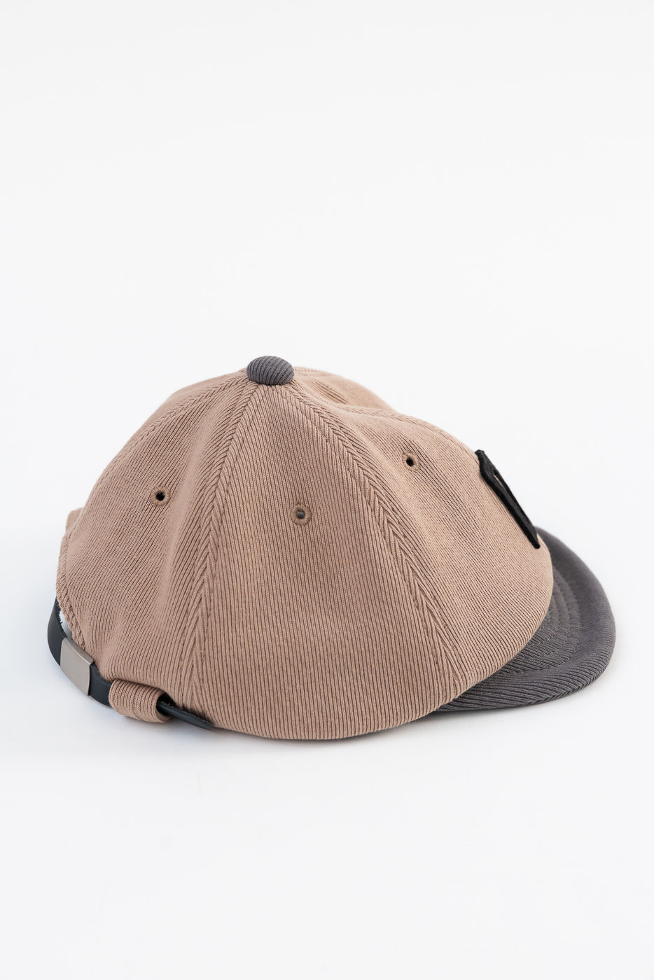 Back view close-up of a tan corduroy baseball cap showing the adjustable strap and texture.