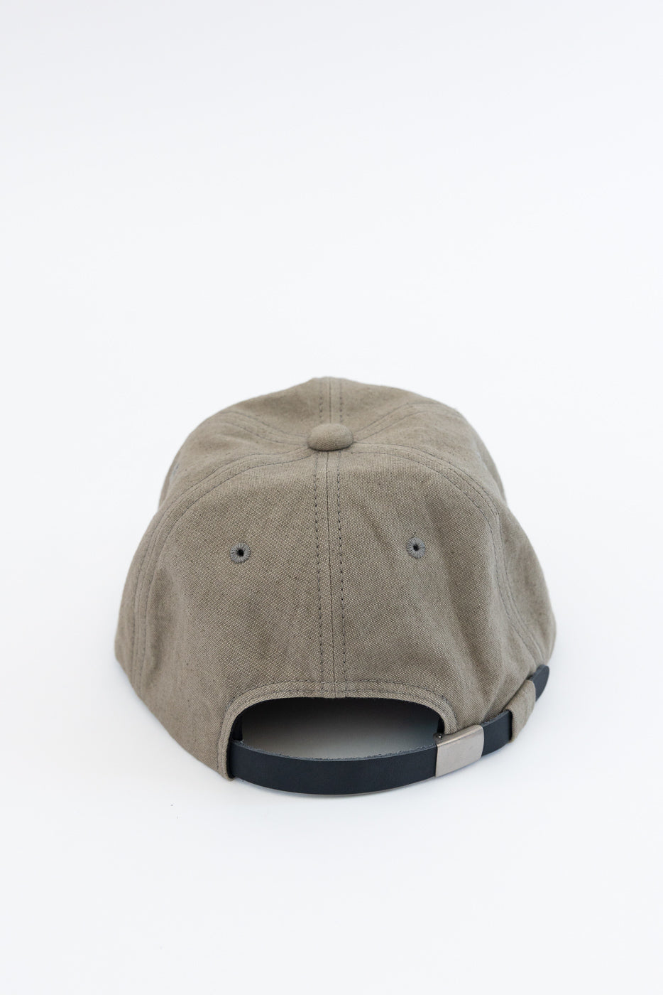 Back view of olive canvas cap with black adjustable strap, metal buckle, and stitched eyelets on white background