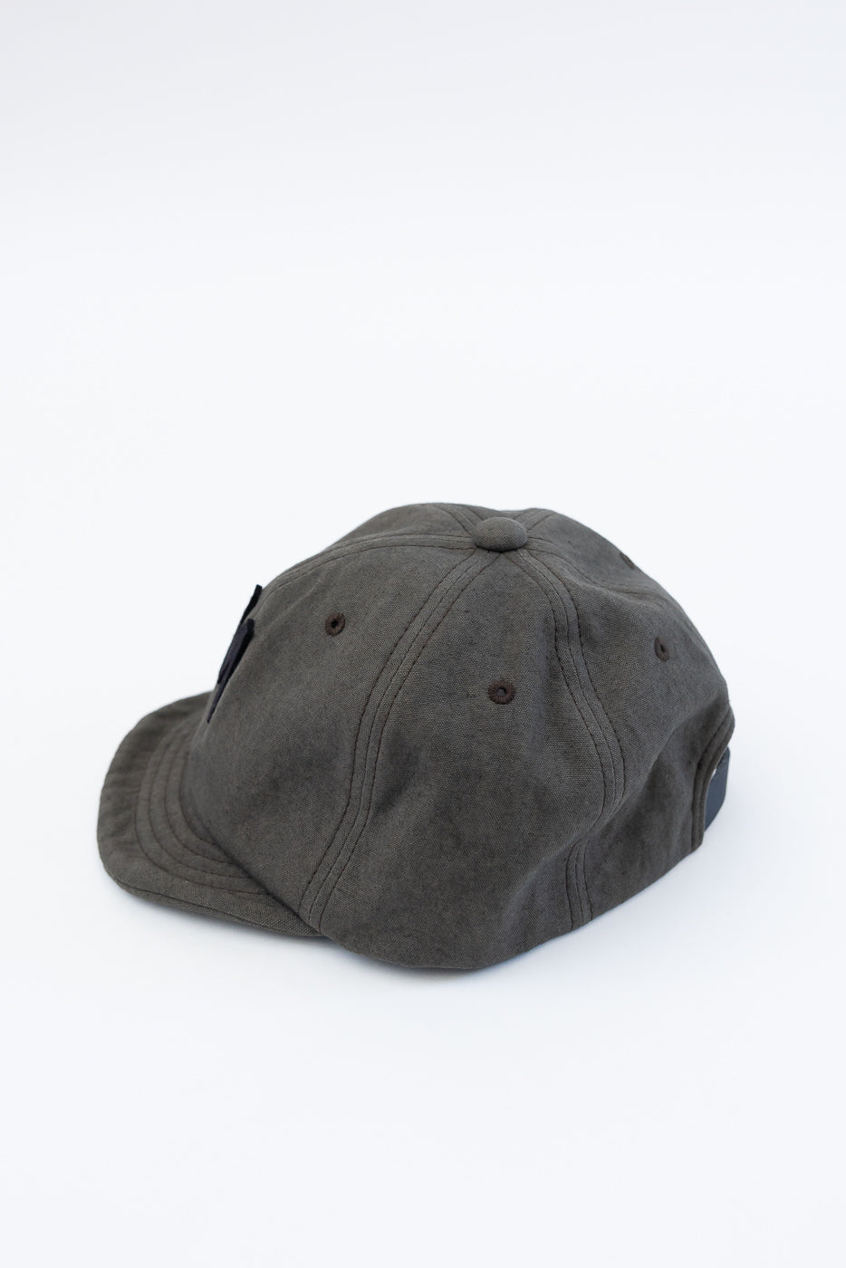 Angled view close-up of dark moss gray canvas ball cap showing side and back panels