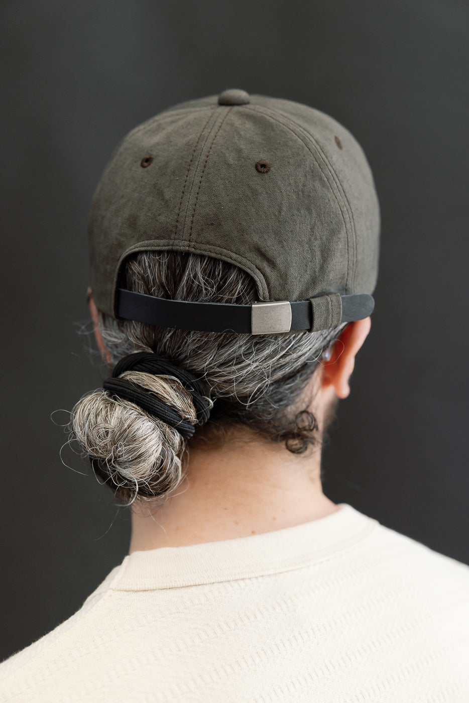 Close-up back view of dark moss gray canvas cap on male model, 5'9
