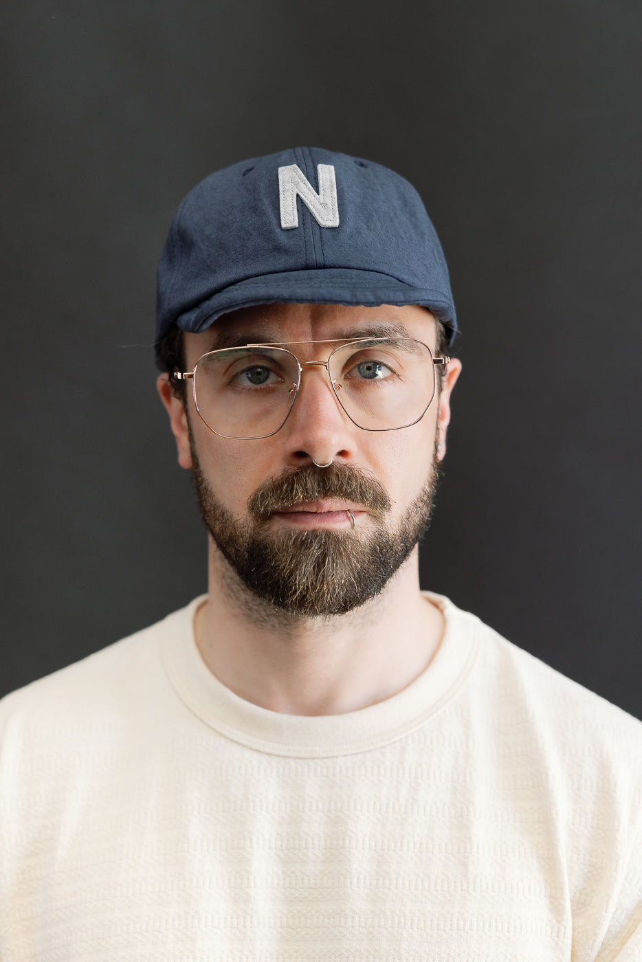 Front close-up of navy canvas baseball cap with N logo, on male model 5'9