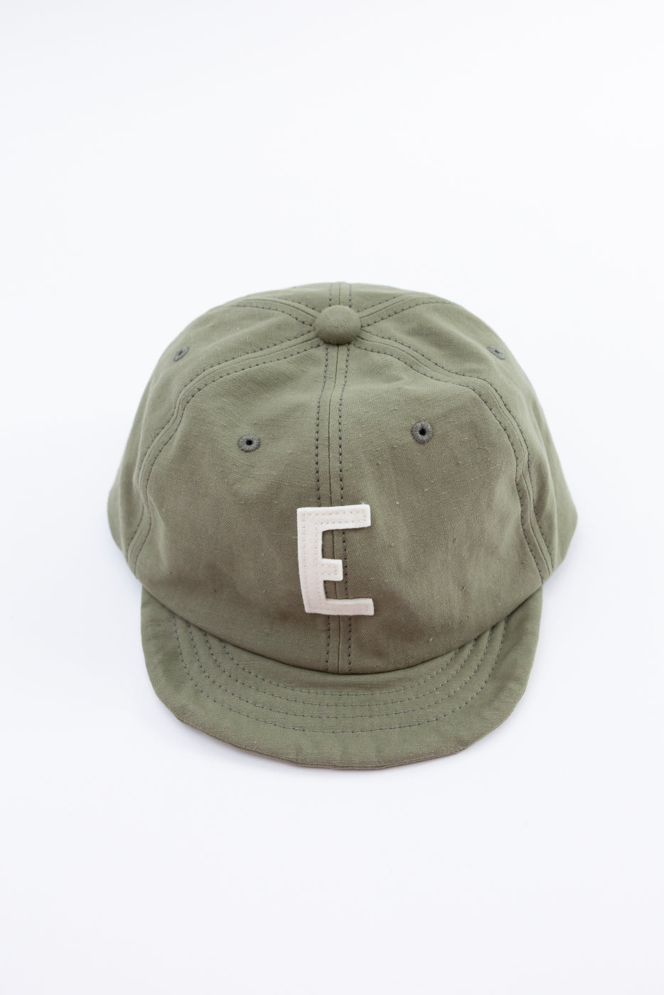 Green cap with a white 'E' on a white background