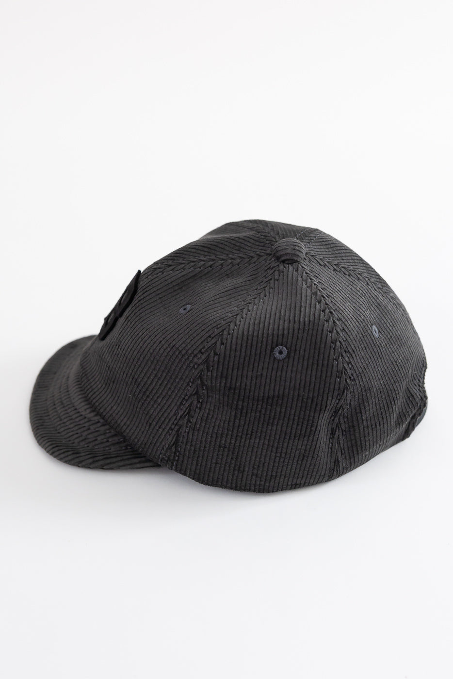Close-up of Jackman black corduroy cap, back and side view, textured fabric detail