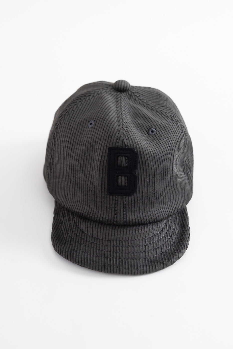 Front close-up of fade black corduroy baseball cap with raised B logo, Dant accessories