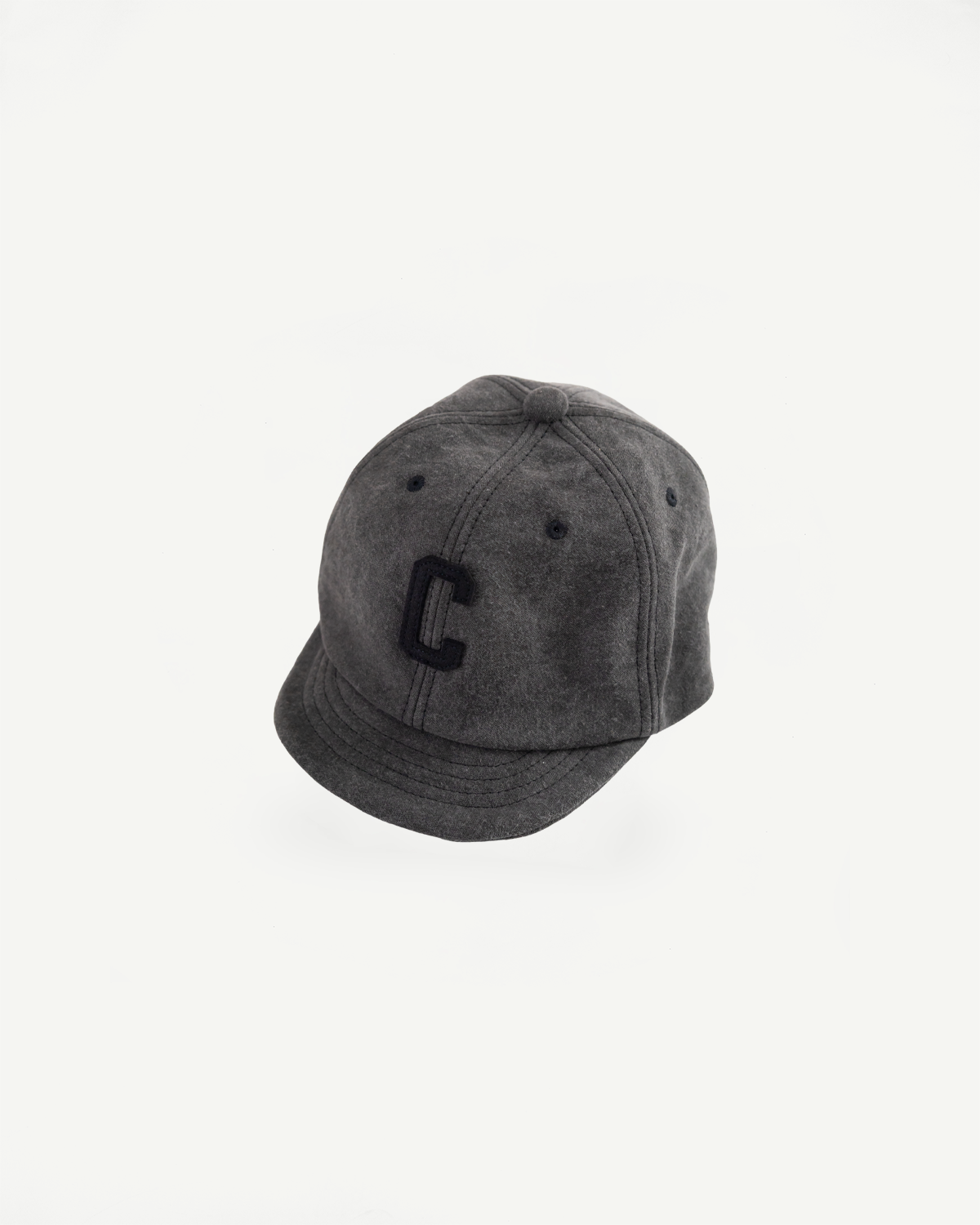 Front view flat lay of black Jackman JM6575 Sumi BB Cap with embroidered C, curved brim, visible cap panels.