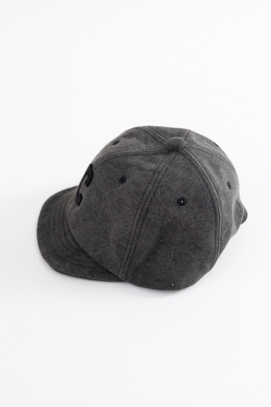 Close-up of black Jackman JM6575 Sumi BB Cap, showing top and left side details, flat lay