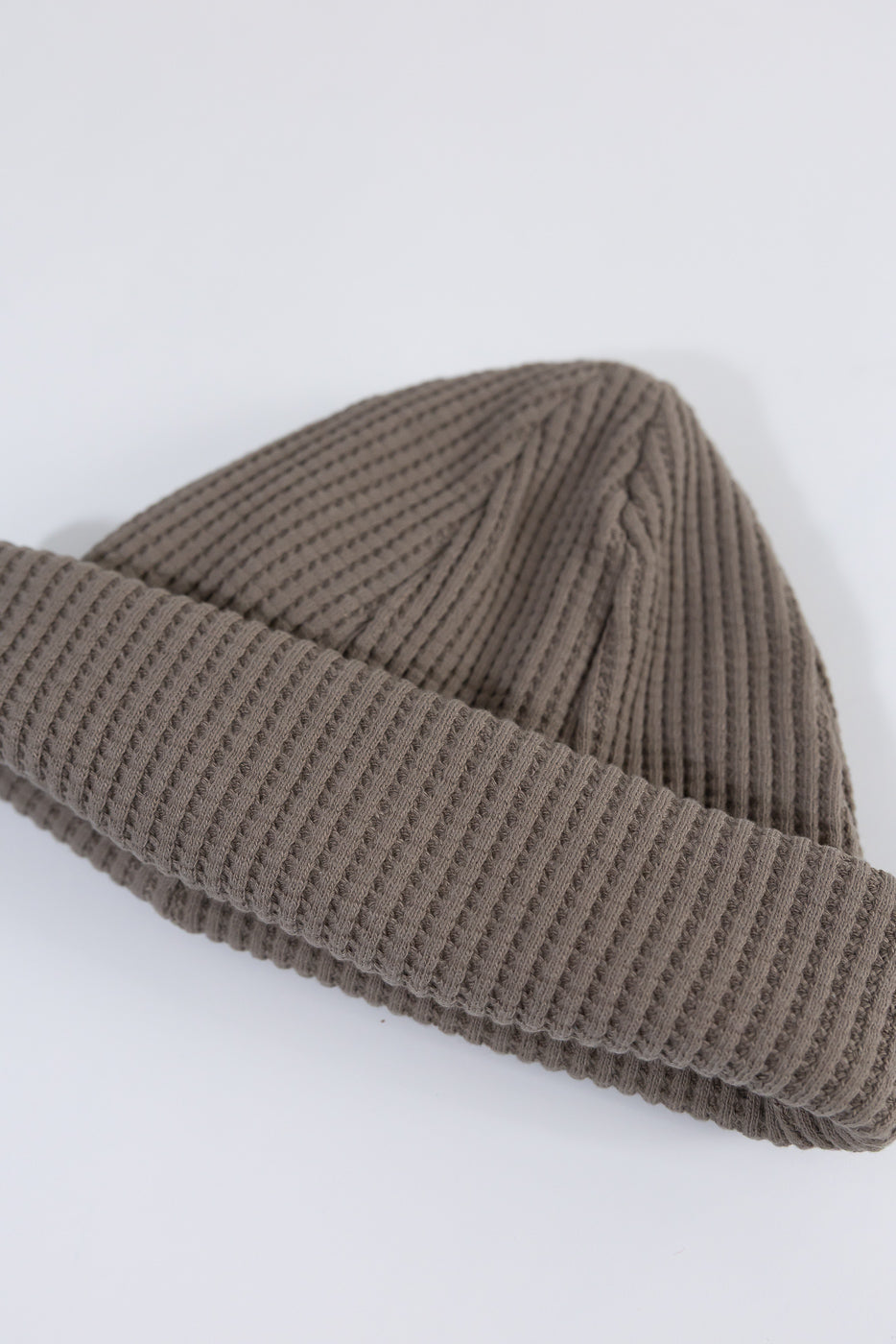 Close-up of Jackman JM6605 waffle knit cap in sepia, flat lay showing front texture and ribbed cuff.