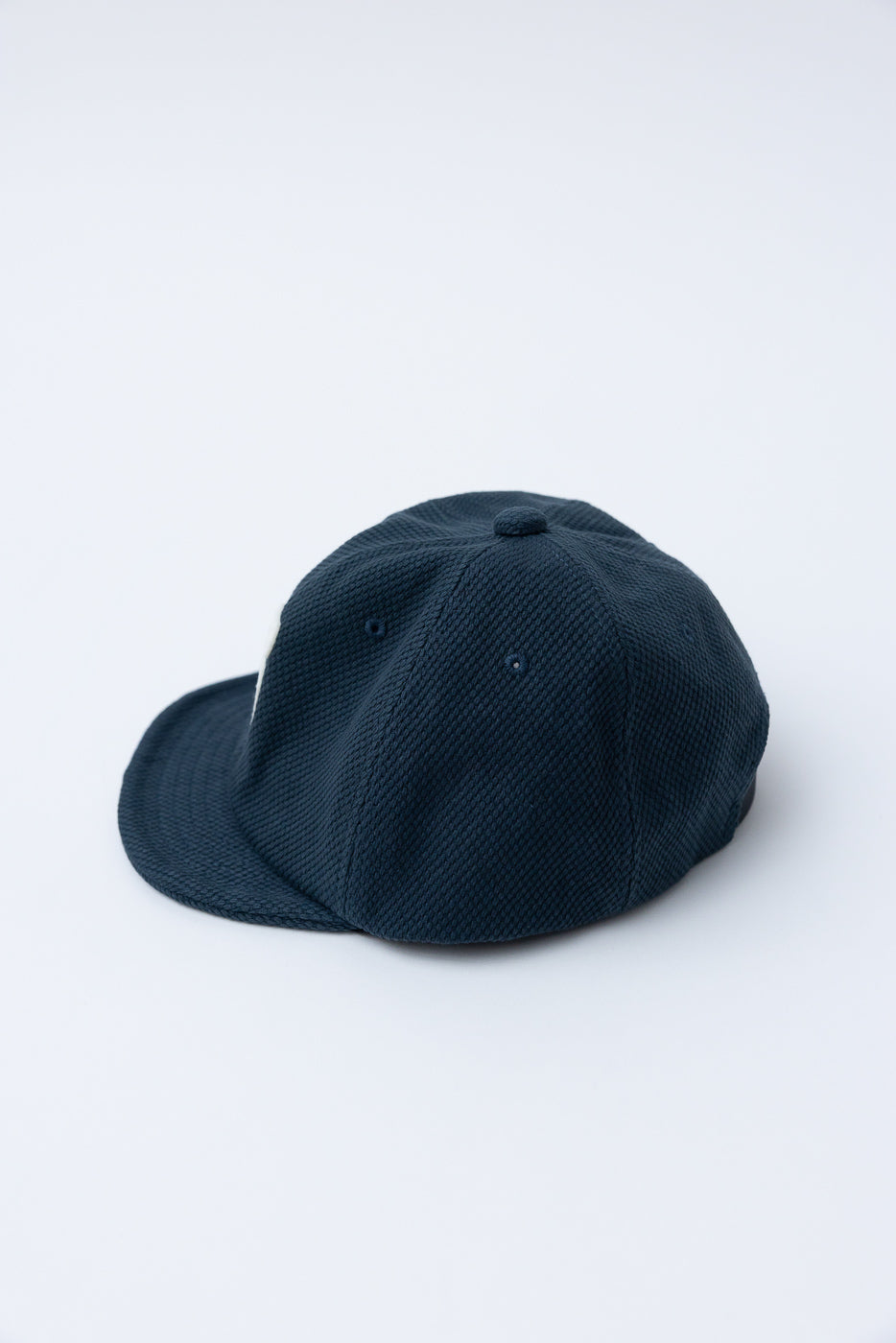 JM6623 - Sashiko BB Cap S - 280 Iron Navy, crafted from textured sashiko fabric, reflects Japanese heritage. The dark-navy, six-panel design exudes timeless style, epitomizing Dant's commitment to premium menswear craftsmanship.