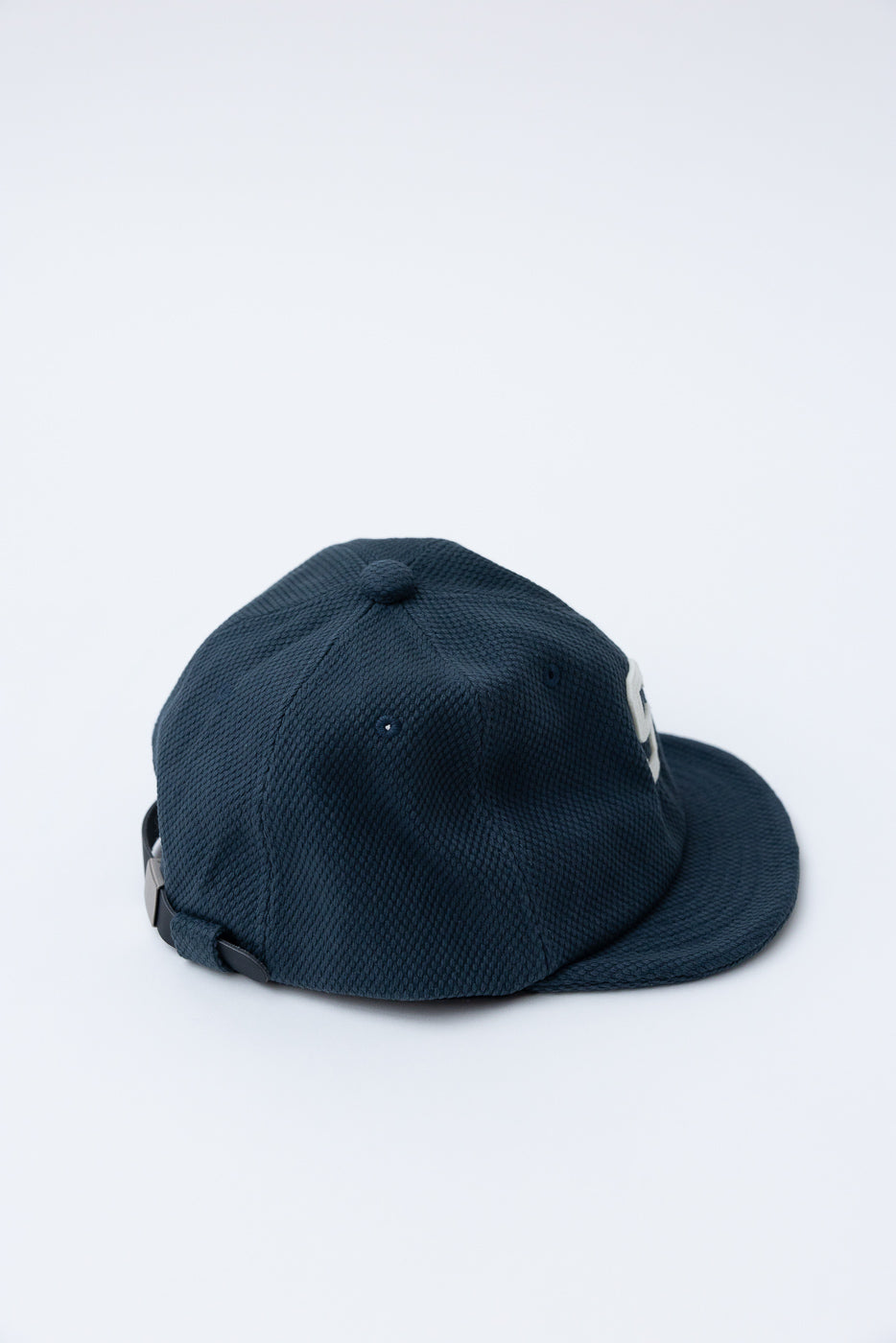 JM6623 - Sashiko BB Cap S - 280 Iron Navy: A navy-blue baseball cap in textured sashiko fabric with a white embroidery on the front, adjustable metal-buckle strap, and curved brim, highlighting heritage craftsmanship.