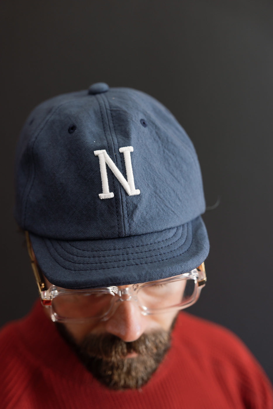 Close-up front view of a navy blue baseball cap with a white embroidered letter N.