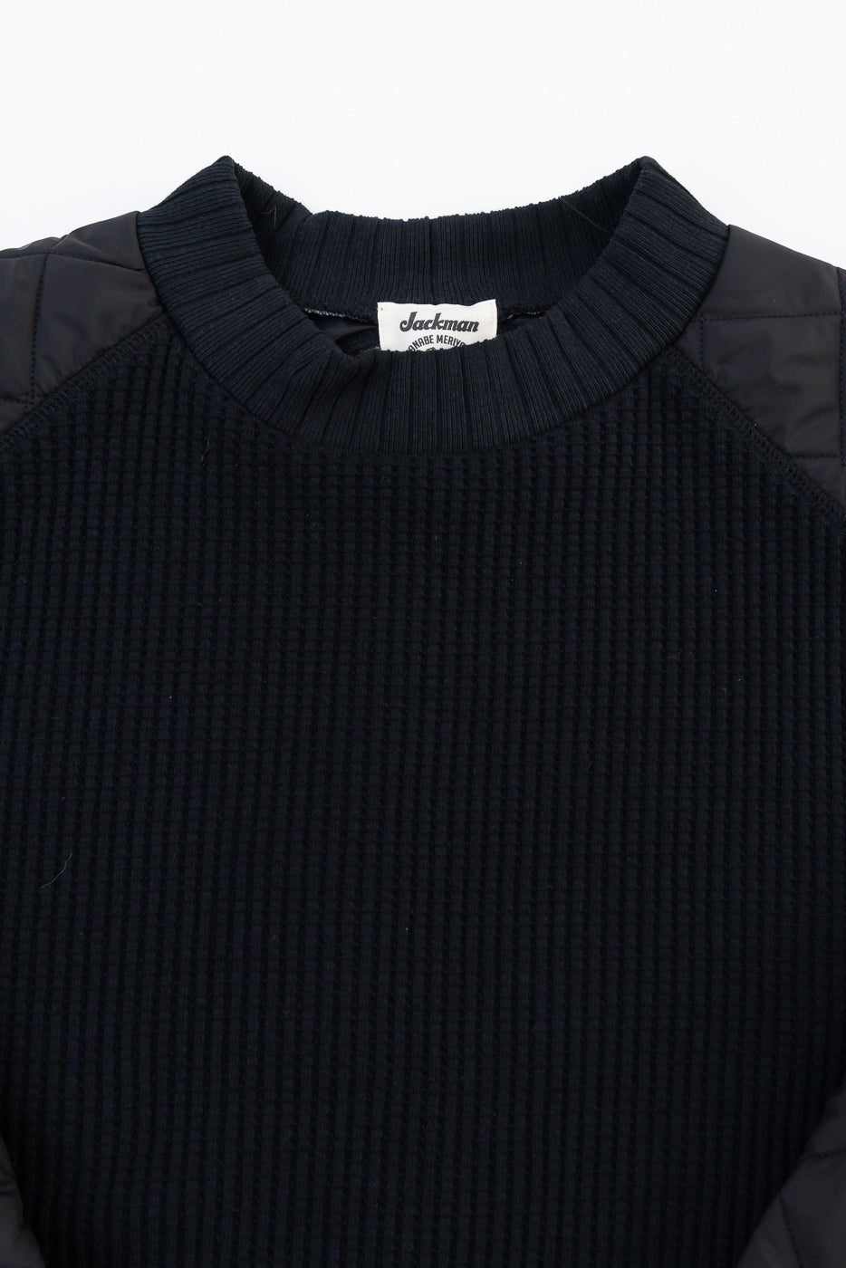 Close-up front view of a black waffle-knit sweater collar and textured fabric detail.