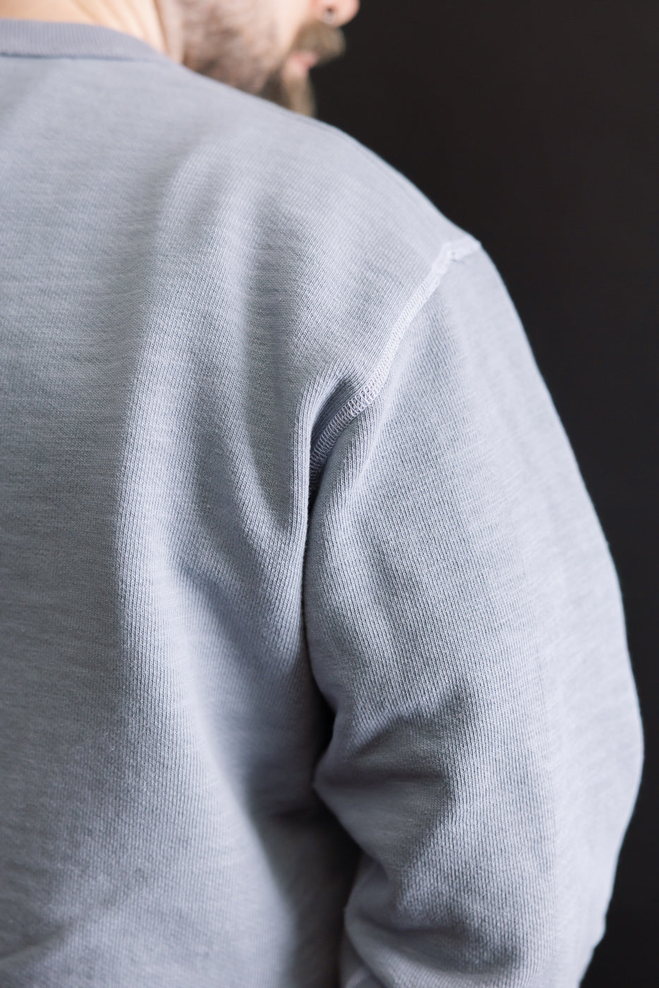 Close-up of the JM7292 - GG Sweat Crewneck - 354 Dry Purple, showcasing its textured knit fabric and stitching on the shoulder seam, highlighting the garment's unique grainy character and craftsmanship.