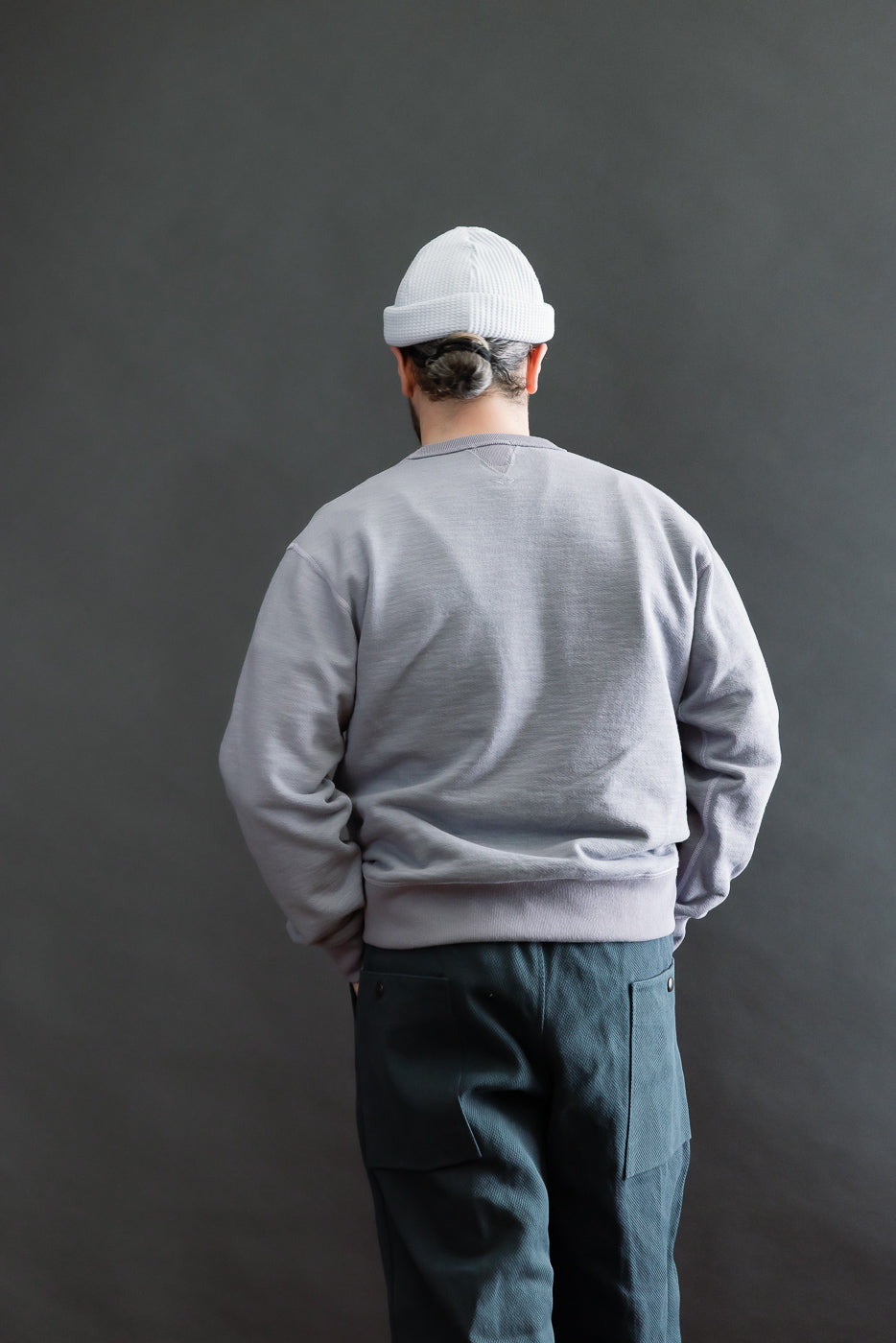 Person wearing JM7292 - GG Sweat Crewneck, visible from back. Features raglan sleeves, reinforced seams, and extra-long ribbing, showcasing the sweatshirt’s unique texture and structure from premium Japanese craftsmanship.