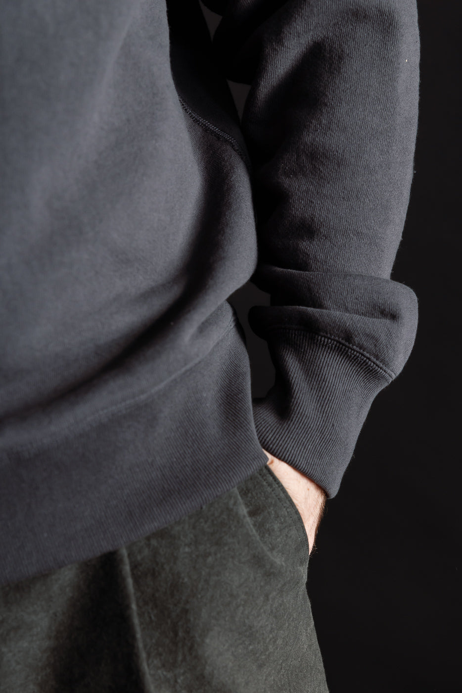 Close-up of front left hem and cuff on Jackman Big Loop Crewneck in ink black, male model, Dant