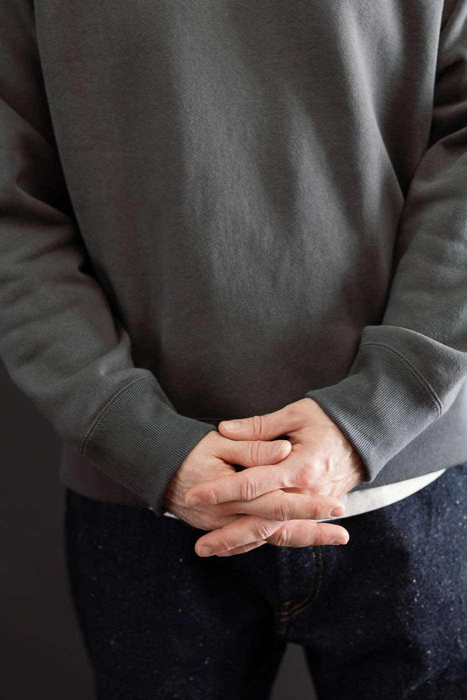 Close-up front view of a grey sweatshirt on a male model, 5'9