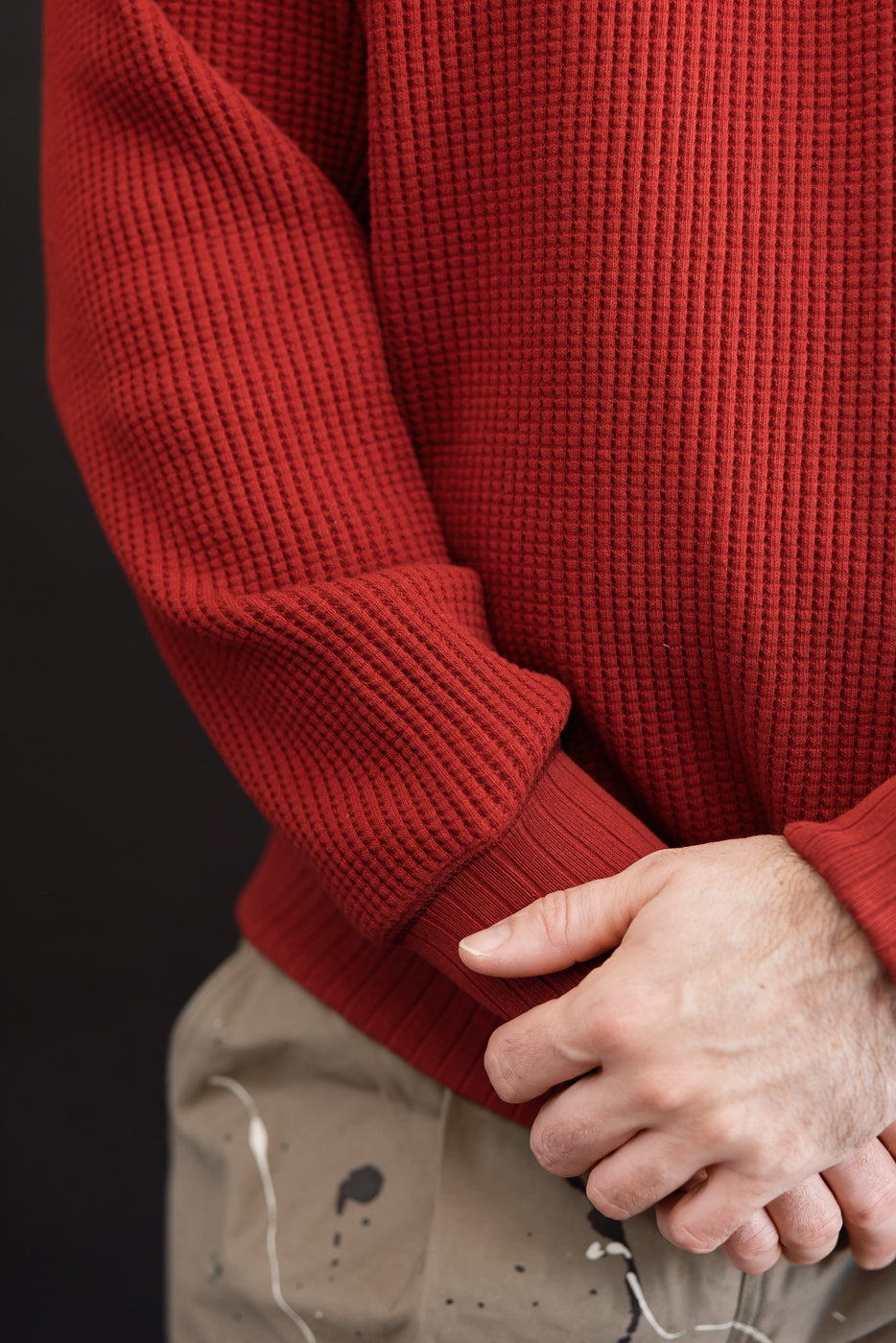 Close-up side view of a red waffle knit thermal sweater on a 5'9