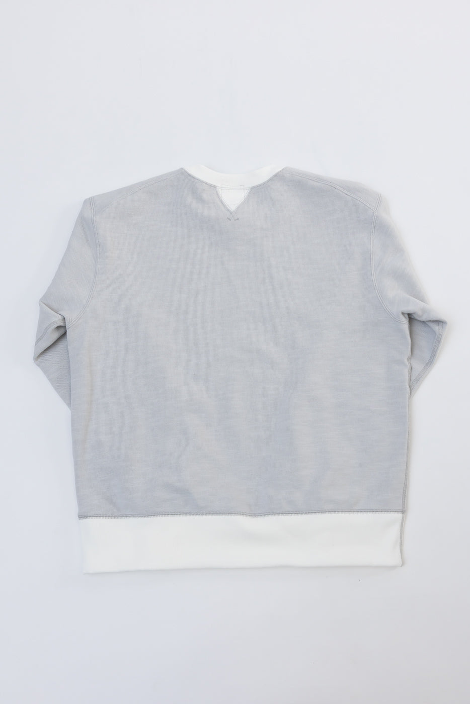 Back view flat lay of a grey heathered crewneck sweatshirt with white ribbed hem.