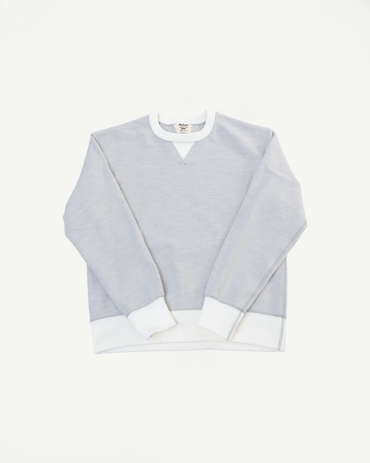 Flat lay front view of a light grey sweatshirt with white crewneck and cuffs.