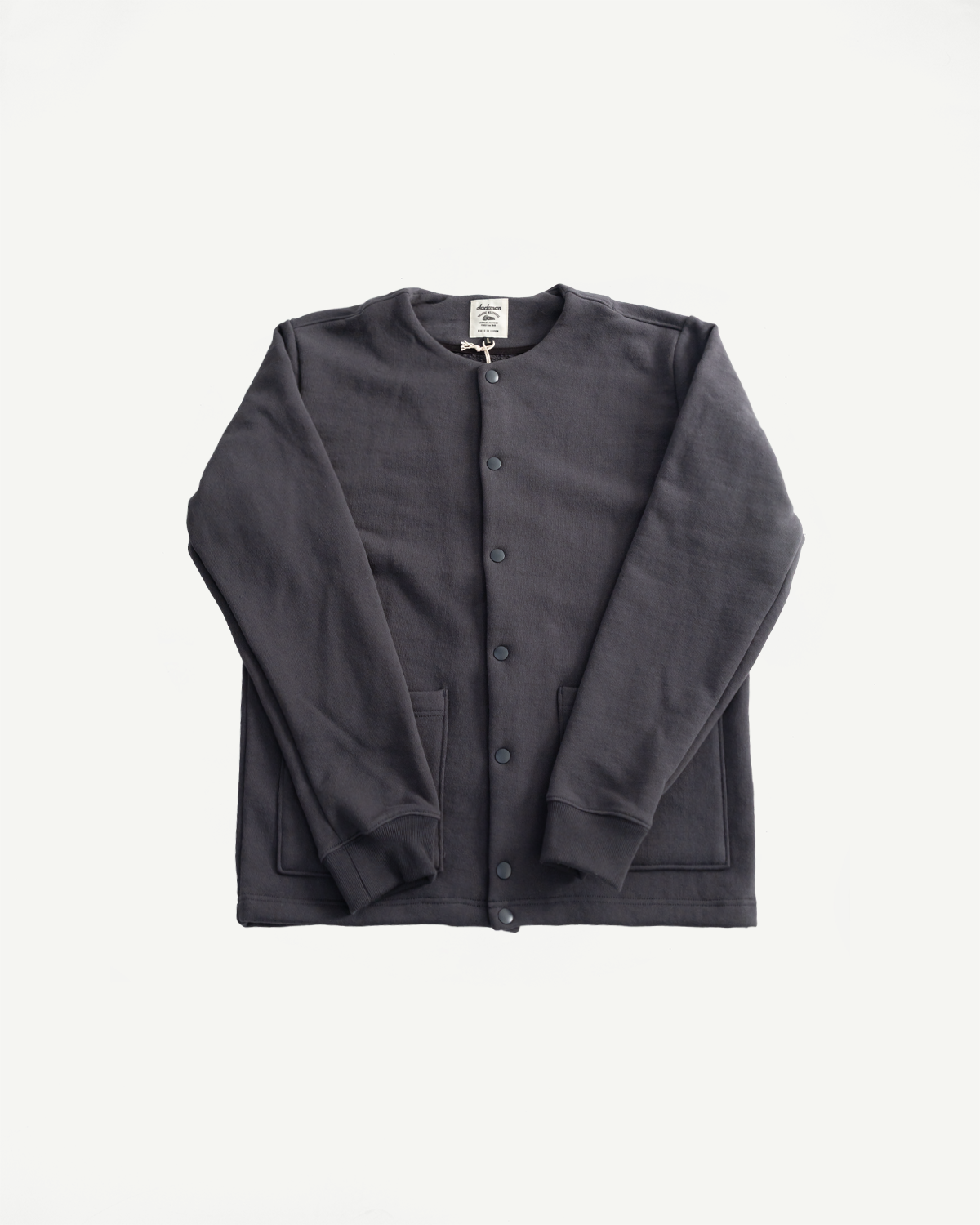 Flat lay front view of Jackman JM8580 Big Loop collarless jacket in ink black, button front, patch pockets, visible texture, Dant contemporary casual apparel.