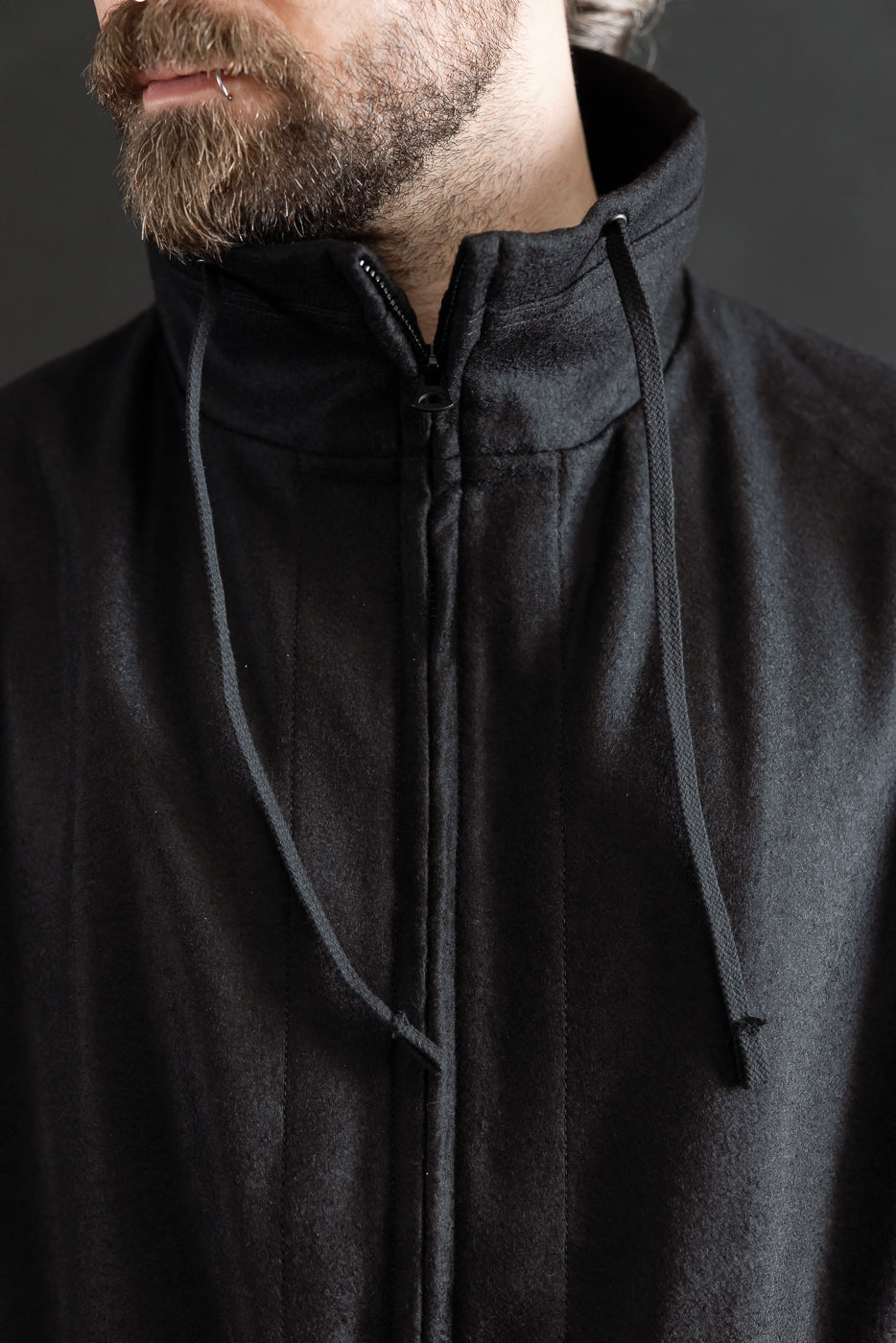 Close-up of front chest and collar on black wool stand-neck jacket, male model 5'9